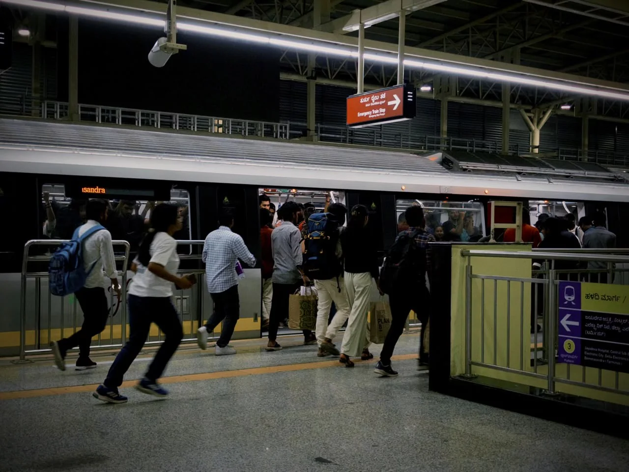 Passengers boarding a metro train at a busy station.