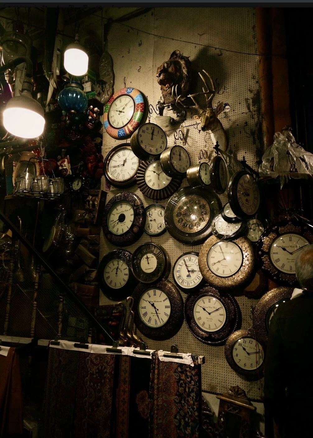 A collection of clocks and lamps on a wall.