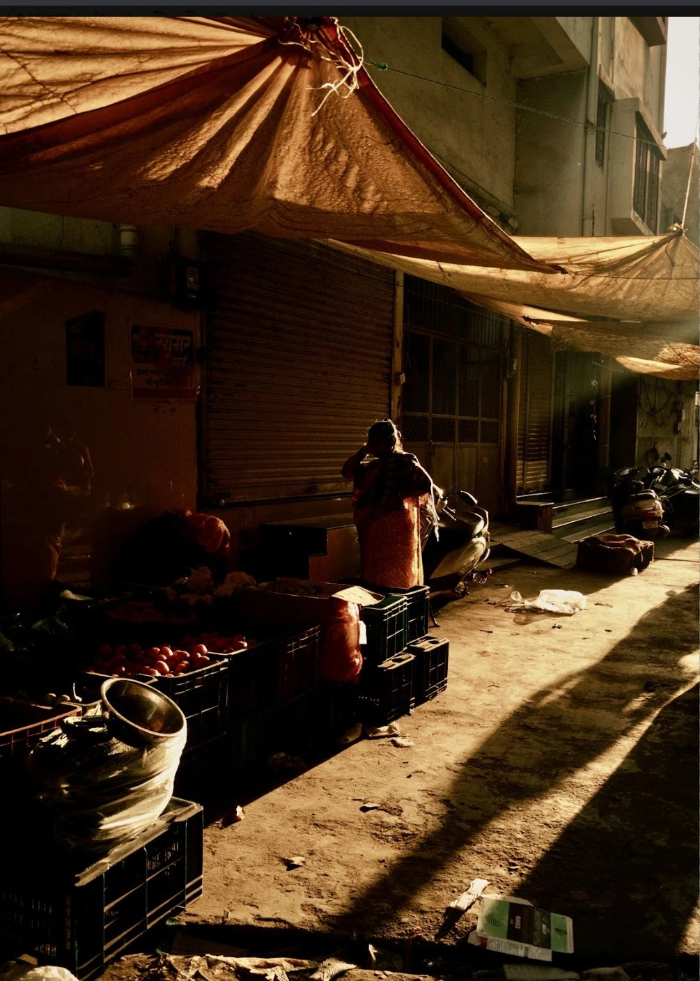 A market stall beneath fabric awnings in afternoon light.